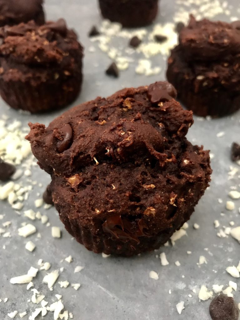 Close up chocolate cauliflower muffin, on a gray background, surrounded by chocolate chips and cauliflower rice. 