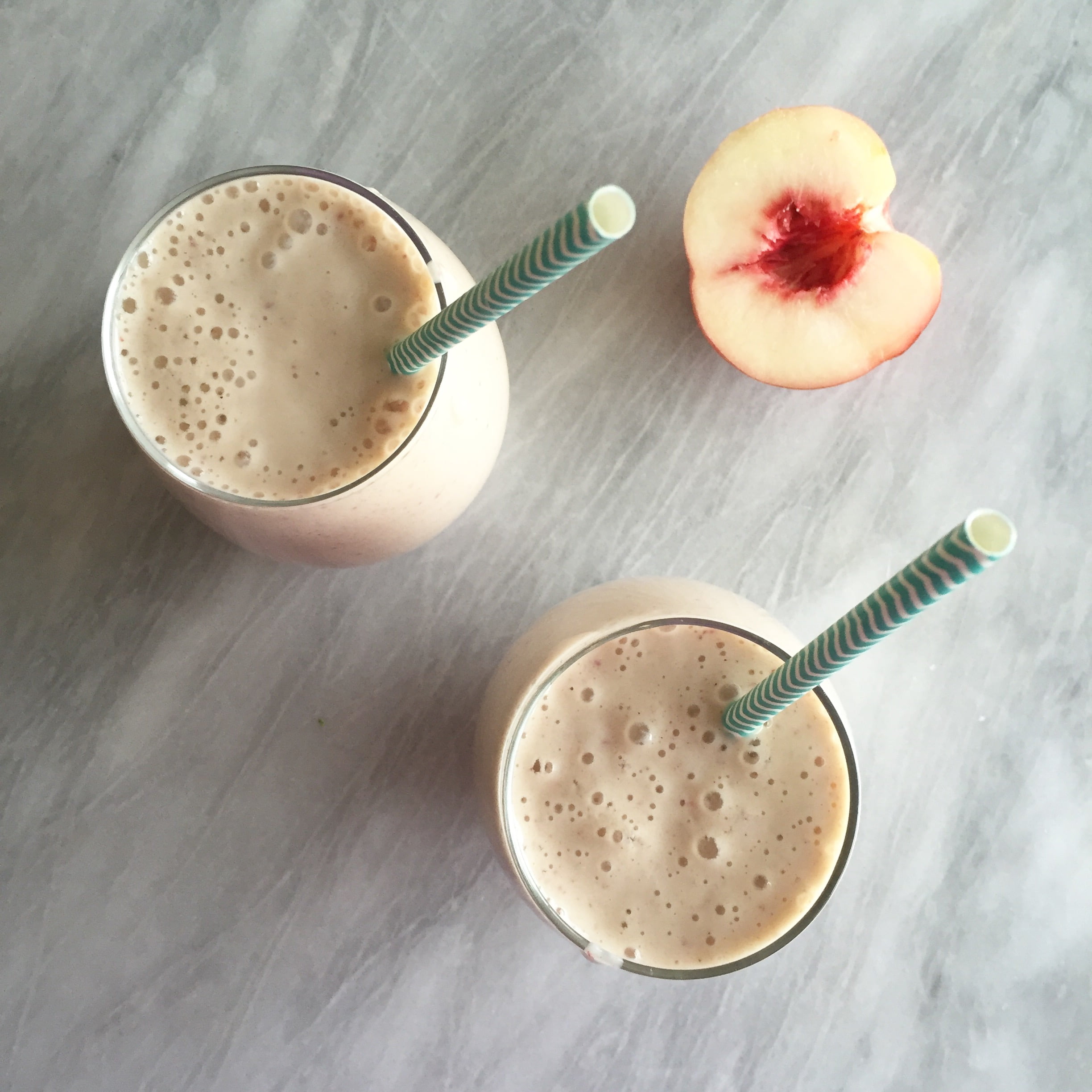Peaches and cream smoothie on a marble background.