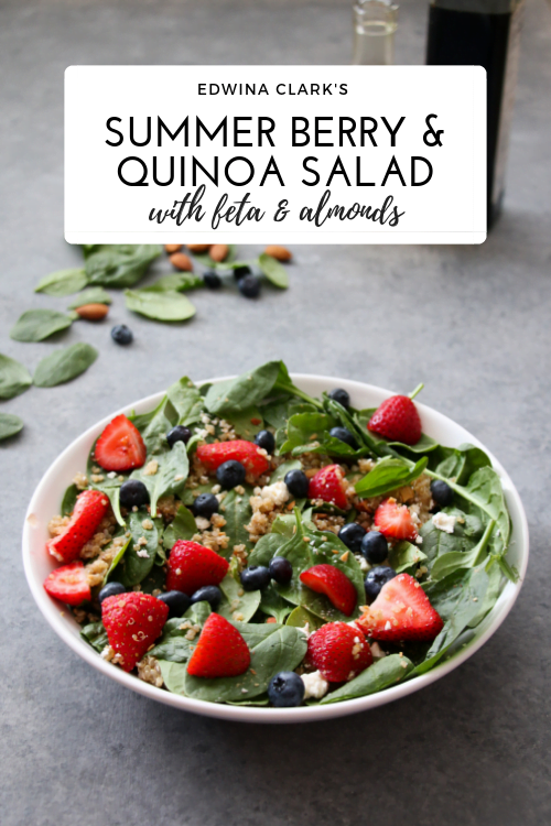 Summer quinoa and berry salad in a white bowl on a gray background.