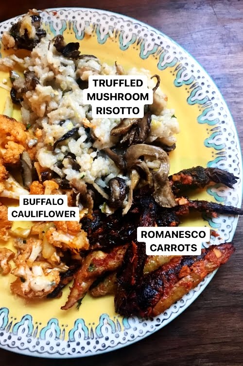Mushroom risotto, romanesco carrots and buffalo cauliflower on a yellow and blue plate, on a dark wood background. 