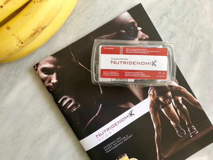 The Nutrigenomix testing kit and report book on a gray background. 