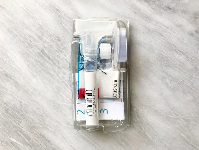 Clear specimen tube on a gray background.