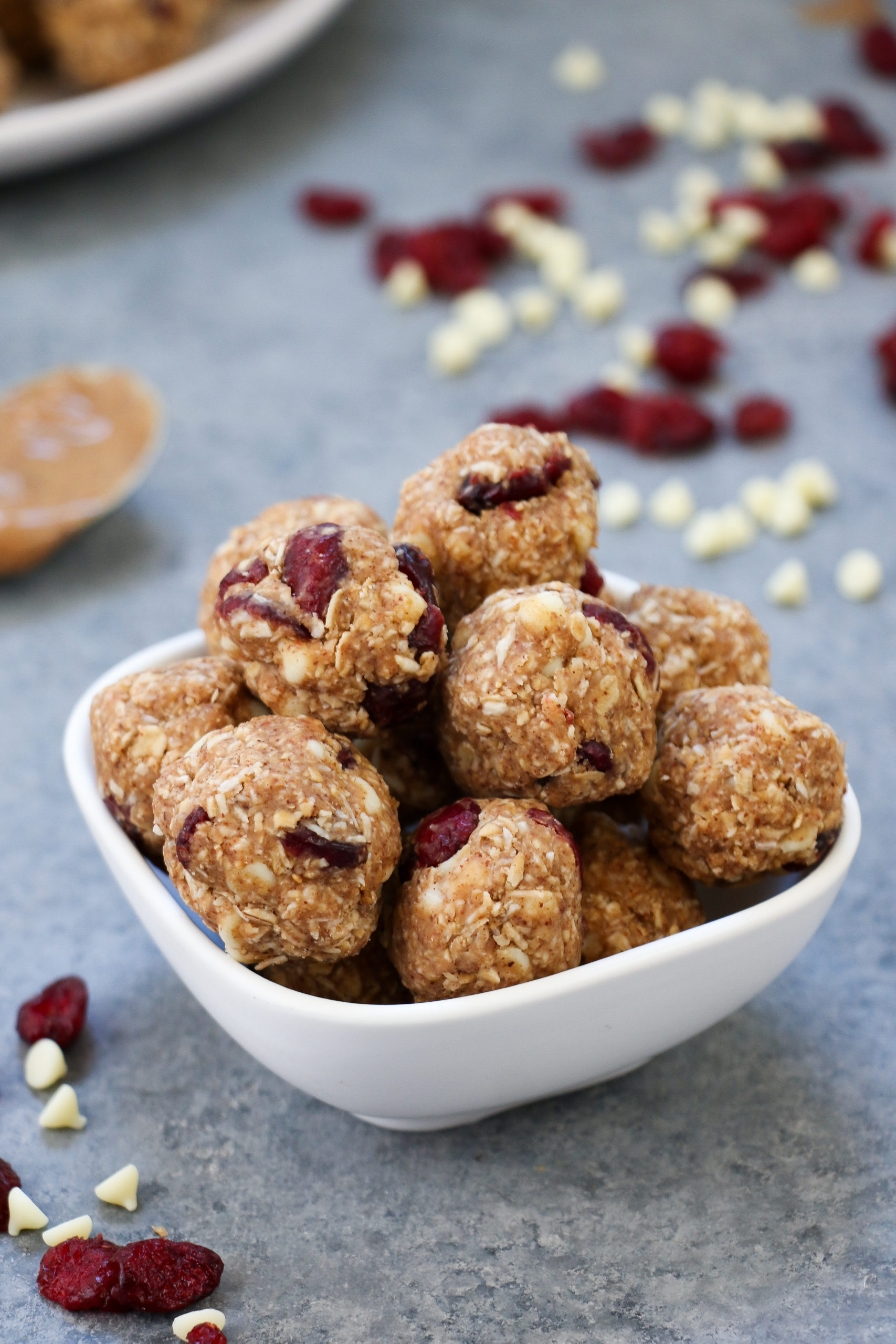 White chocolate-cranberry energy bites in a white bowl on a gray background