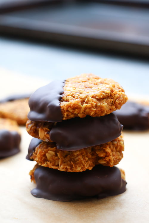 4 chocolate-pumpkin cookies stacked on parchment paper