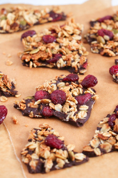 Dark chocolate granola bark pieces on parchment paper