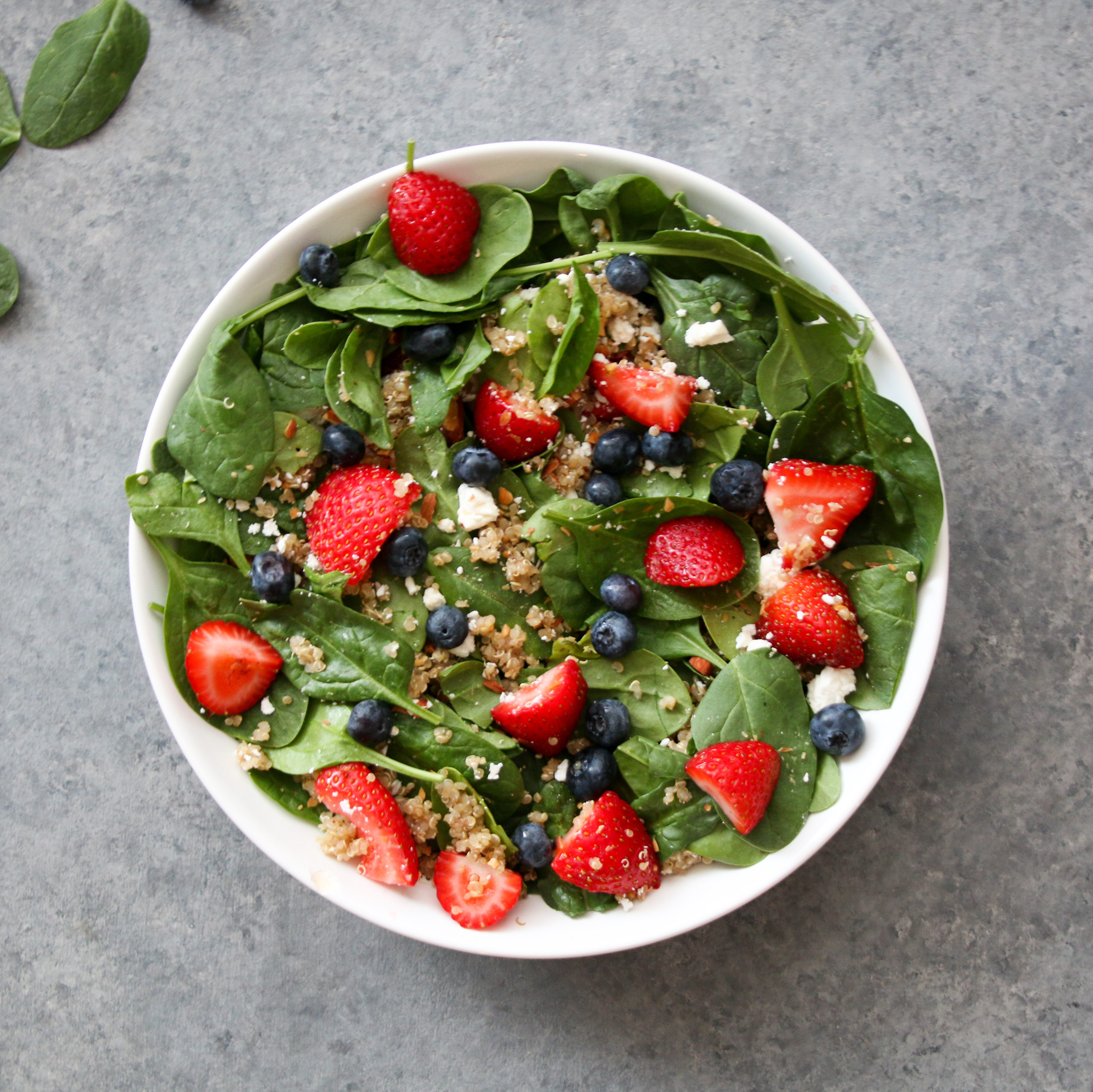 Summer berry and quinoa salad on a gray background